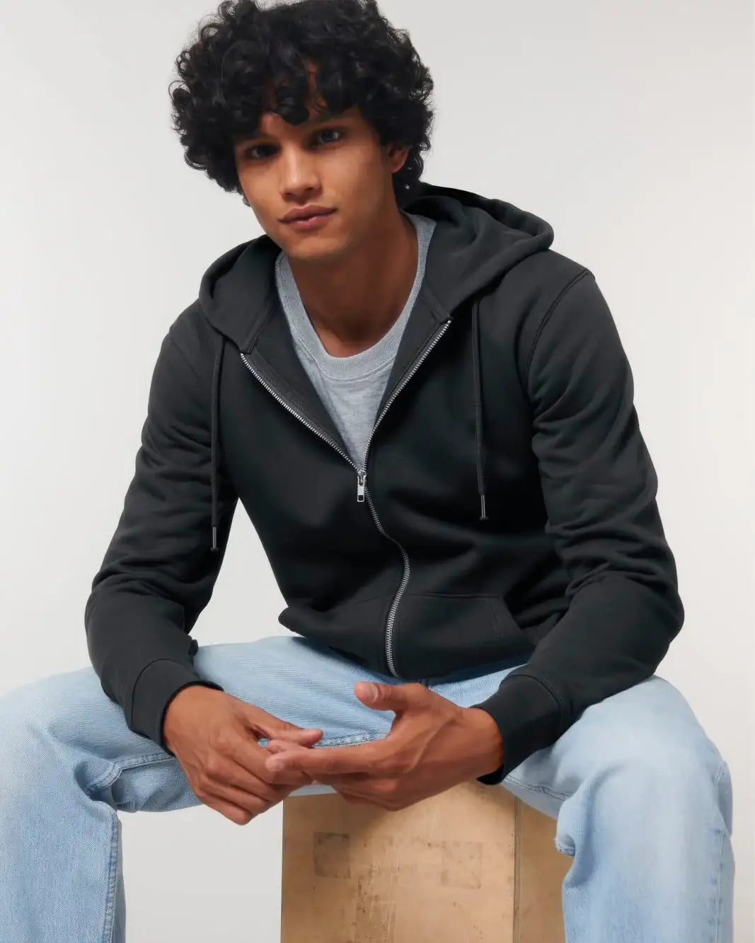 Junger Mann trägt schwarzen Unisex Hoodie mit Reißverschluss und Kapuze, helle Jeans