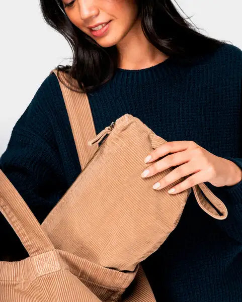 Frau mit nachhaltiger, kleiner Kordtasche in Beige, trägt passendes Outfit