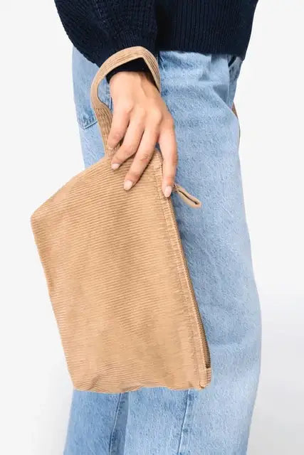 Frau hält eine beige Cordtasche, nachhaltige Mode, lässiges Outfit, Jeans