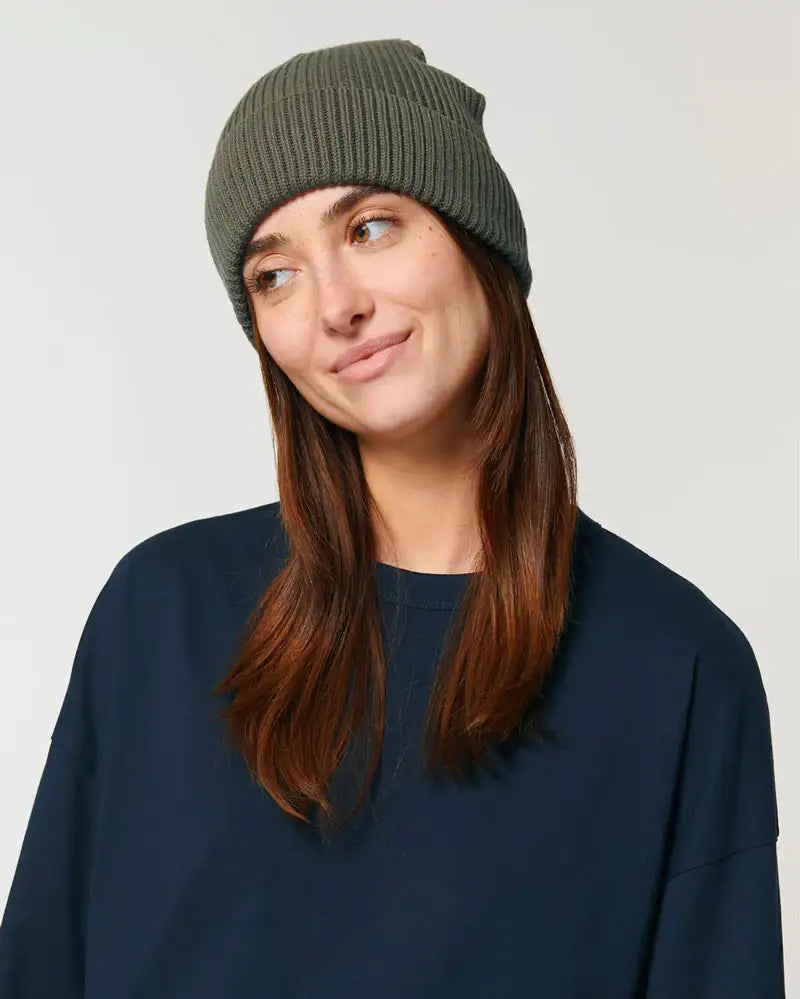 Frau mit olivgrüner Fisherman Beanie Wollmütze und dunkelblauem Pullover, Porträt