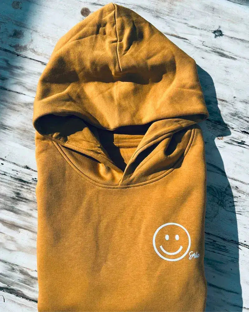 Gelber Kinder Hoodie mit Smiley Print auf der Brust, nachhaltige Mode, flach gefaltet