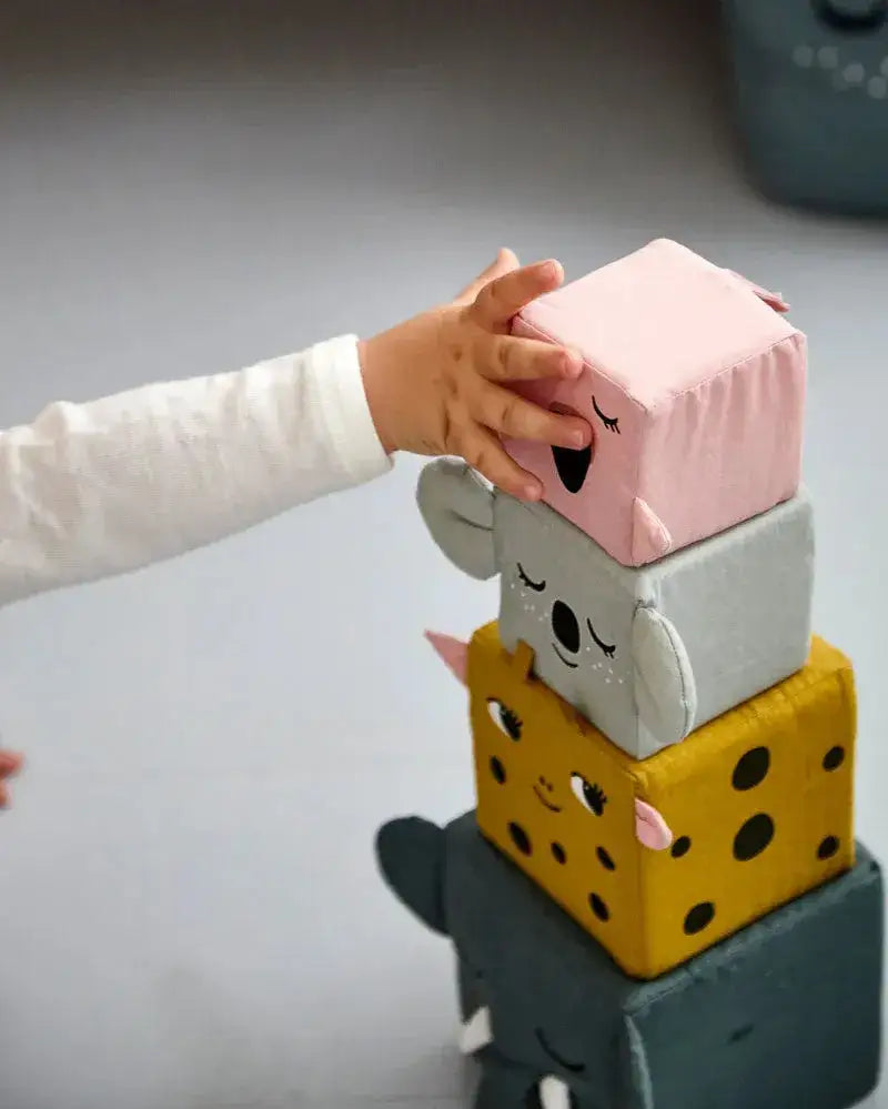 Kindhand stapelt weiche Tier-Greifwürfel aus Stoff: Elefant, Tiger, Koala, Flamingo