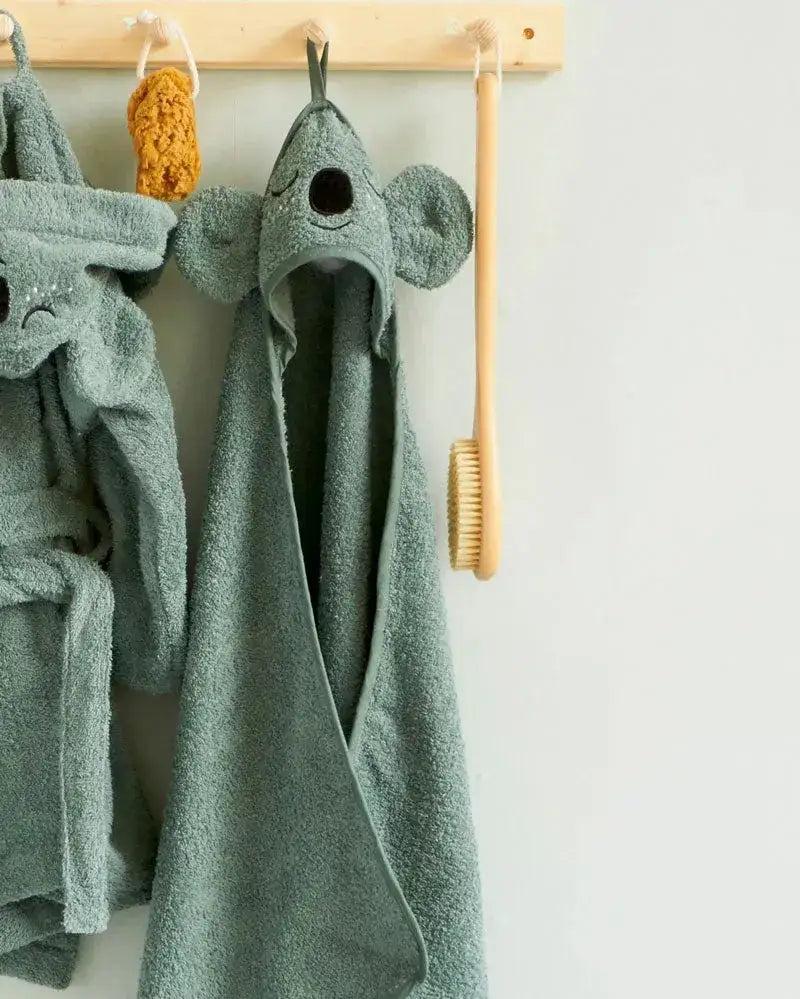 Grünes Kinderhandtuch mit Kapuze und Koala-Gesicht, aufgehängt im Badezimmer