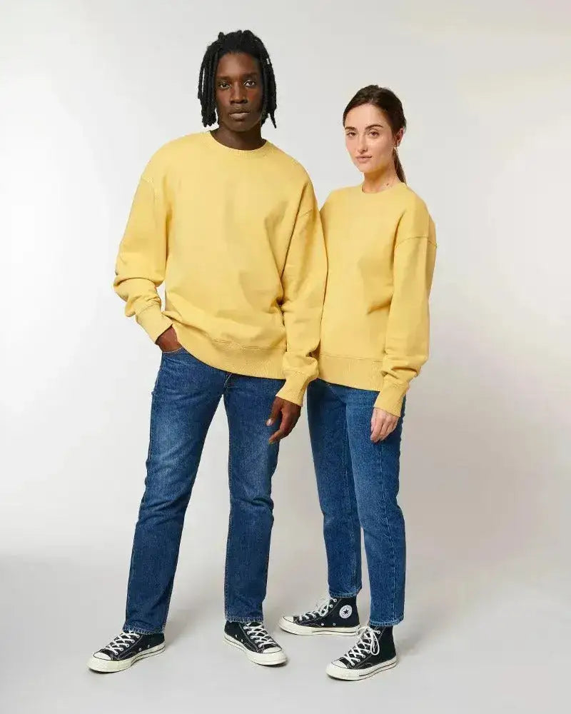 Zwei Personen tragen gelbe Unisex Sweatshirts und blaue Jeans, nachhaltige Mode